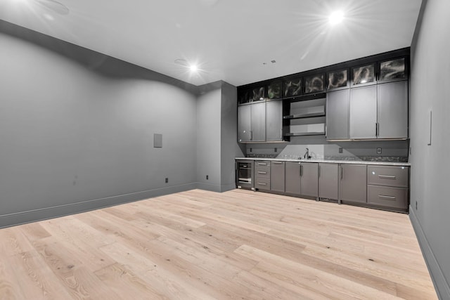 kitchen featuring sink, light wood-type flooring, and wine cooler