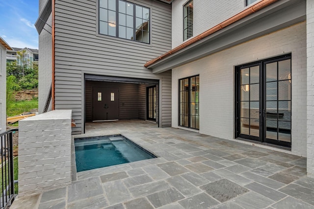 view of swimming pool featuring french doors and a patio area