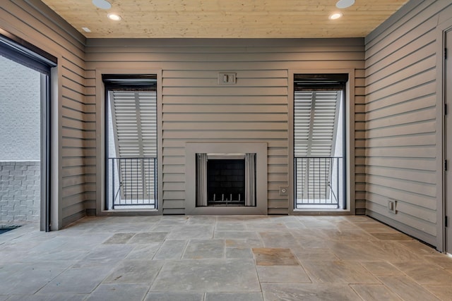 unfurnished living room with a fireplace and wood ceiling