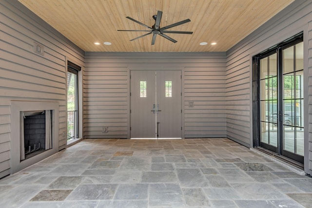 entrance foyer featuring wooden walls and wooden ceiling