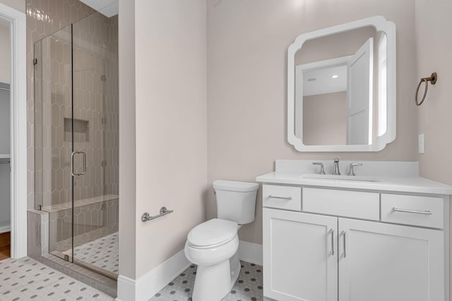 bathroom with toilet, a shower with door, and vanity