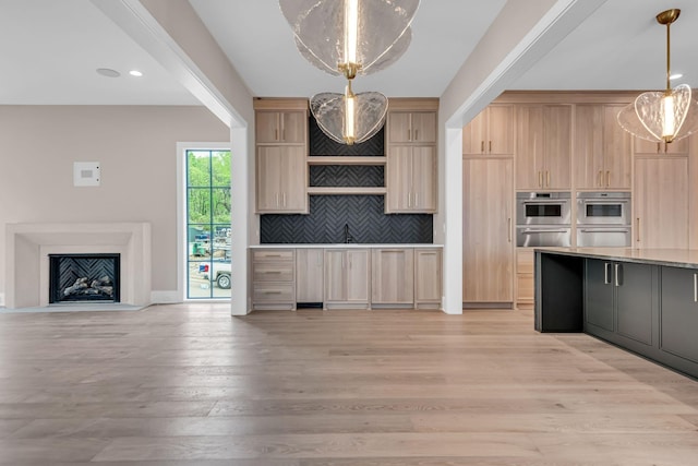 kitchen with decorative light fixtures, light hardwood / wood-style flooring, decorative backsplash, light brown cabinetry, and stainless steel double oven