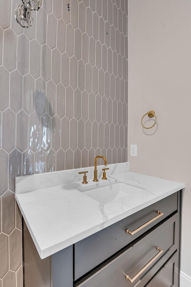 bathroom with tile walls, a notable chandelier, and vanity