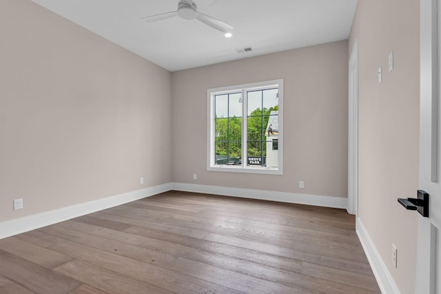 empty room with ceiling fan and light hardwood / wood-style floors