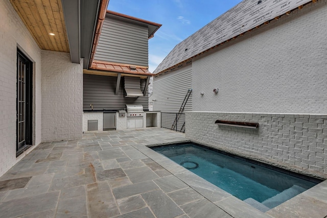 view of swimming pool featuring sink, a patio, area for grilling, a hot tub, and exterior kitchen