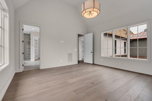 interior space with high vaulted ceiling, light hardwood / wood-style flooring, and a healthy amount of sunlight