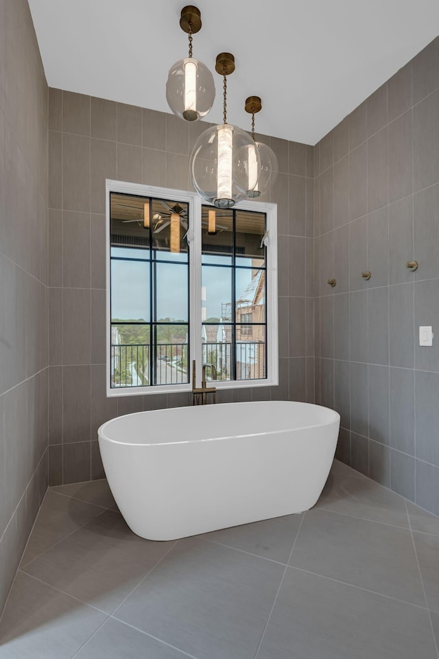 bathroom with tile walls, a bath, and tile patterned floors