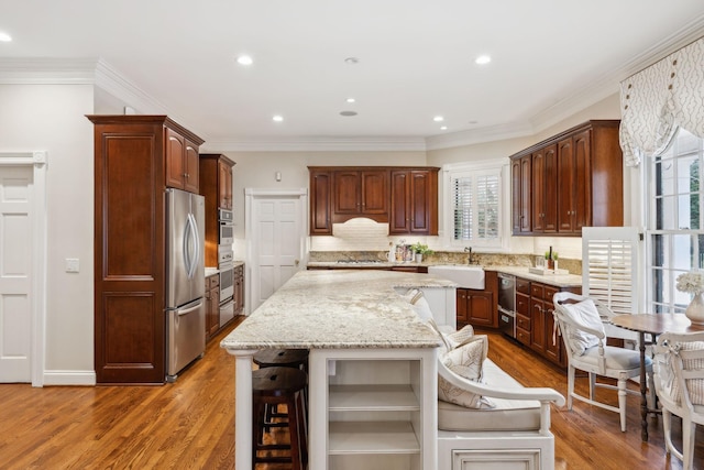 kitchen with stainless steel refrigerator, a center island, a breakfast bar, sink, and tasteful backsplash