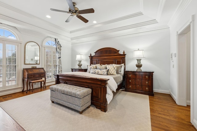 bedroom featuring ceiling fan, light wood-type flooring, ornamental molding, and multiple windows