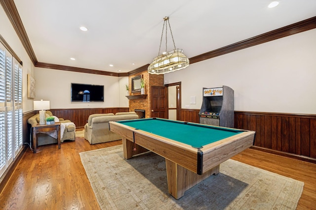 rec room with a fireplace, billiards, ornamental molding, light hardwood / wood-style floors, and wood walls