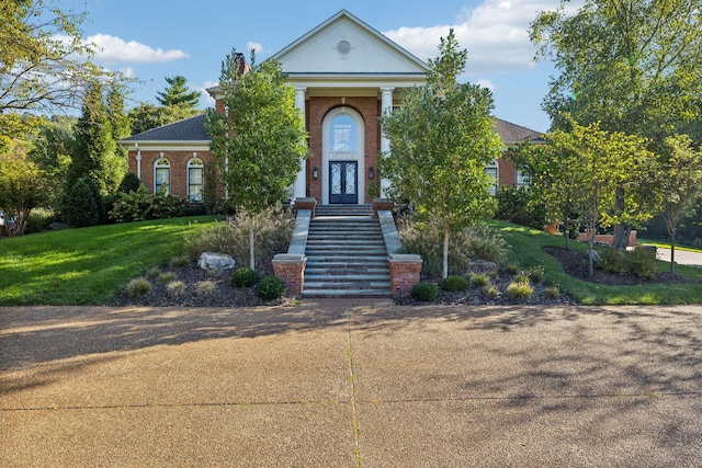 neoclassical / greek revival house featuring a front lawn