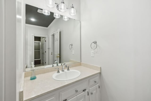 bathroom with ornamental molding and vanity