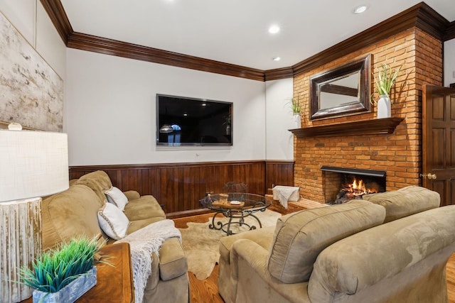 living room with a brick fireplace, crown molding, and hardwood / wood-style flooring