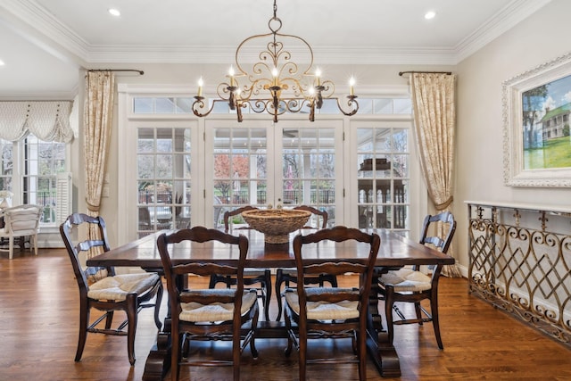 dining area featuring dark wood-type flooring, french doors, a notable chandelier, and crown molding