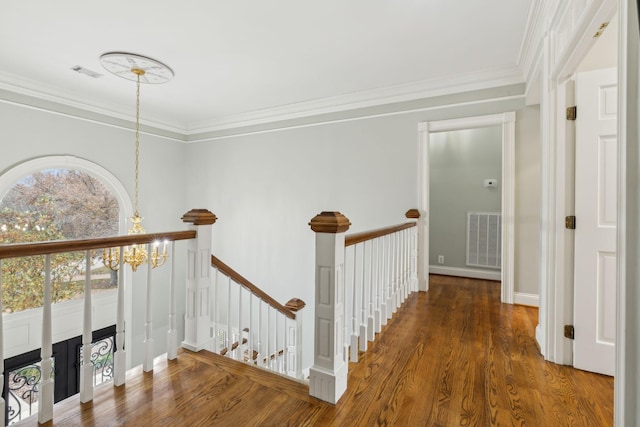 hall featuring dark hardwood / wood-style flooring, an inviting chandelier, and ornamental molding