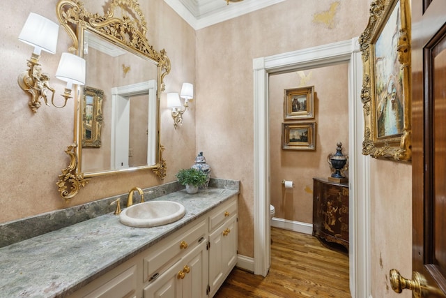 bathroom with ornamental molding, toilet, vanity, and hardwood / wood-style flooring