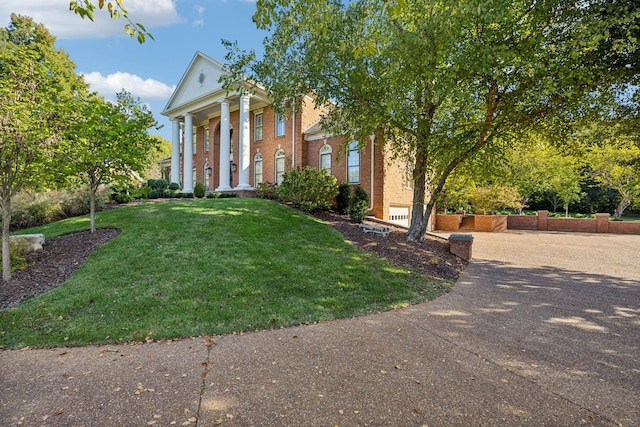 neoclassical home featuring a front yard