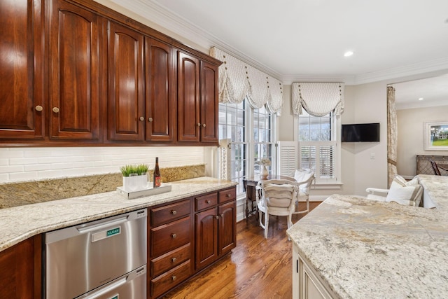 kitchen with stainless steel dishwasher, crown molding, tasteful backsplash, and hardwood / wood-style floors