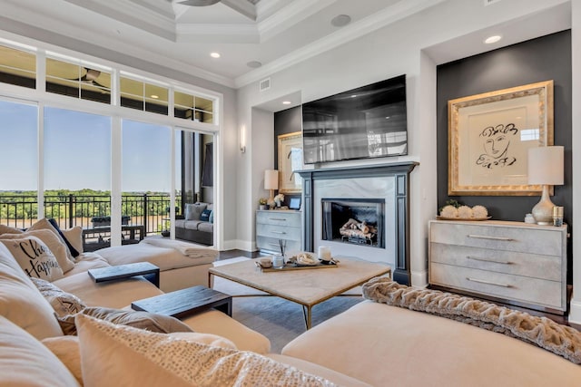 living room featuring a towering ceiling, a premium fireplace, and ornamental molding