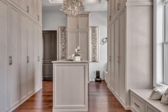 hall featuring dark wood-type flooring and an inviting chandelier