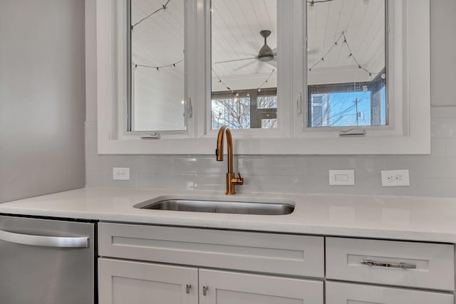 interior space with dishwasher, white cabinetry, sink, backsplash, and ceiling fan