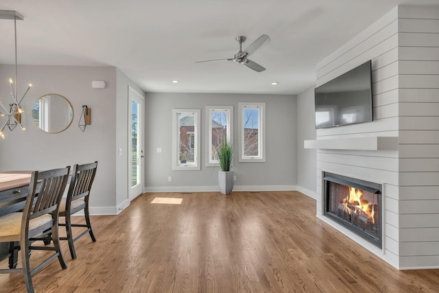 unfurnished living room with hardwood / wood-style flooring and ceiling fan with notable chandelier