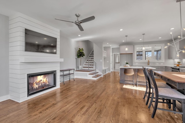 interior space with ceiling fan, hardwood / wood-style flooring, and a fireplace