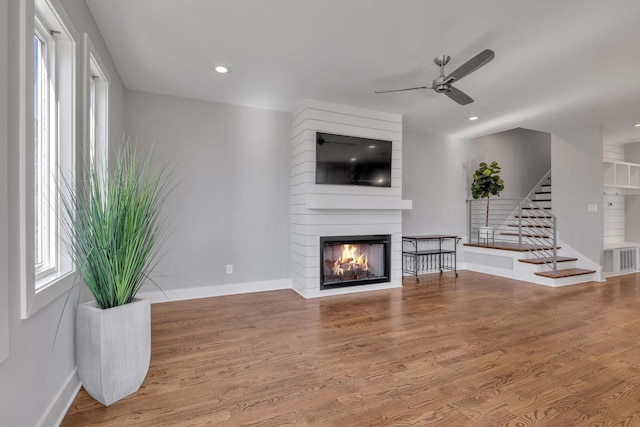 living room with ceiling fan, hardwood / wood-style floors, and a fireplace