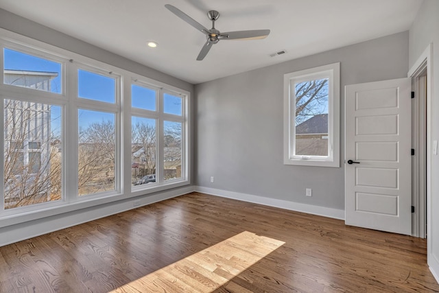 unfurnished room with ceiling fan, hardwood / wood-style floors, and plenty of natural light