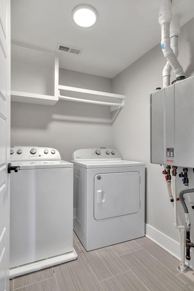 laundry area featuring tankless water heater and washer and clothes dryer