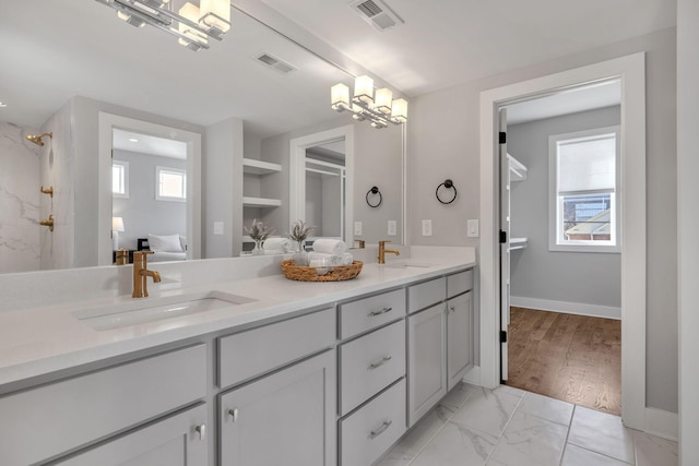 bathroom featuring built in shelves, vanity, and a chandelier