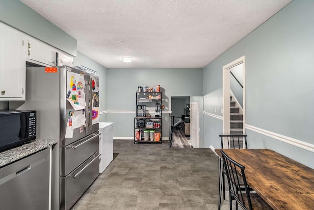 kitchen with white cabinetry, a textured ceiling, and appliances with stainless steel finishes