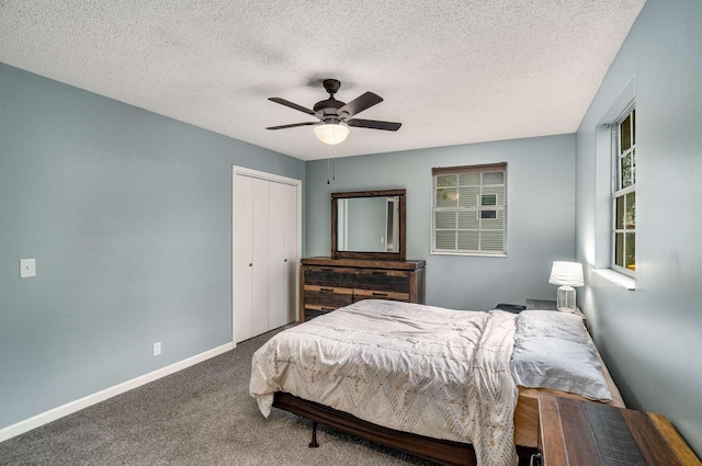 bedroom featuring a textured ceiling, ceiling fan, a closet, and carpet