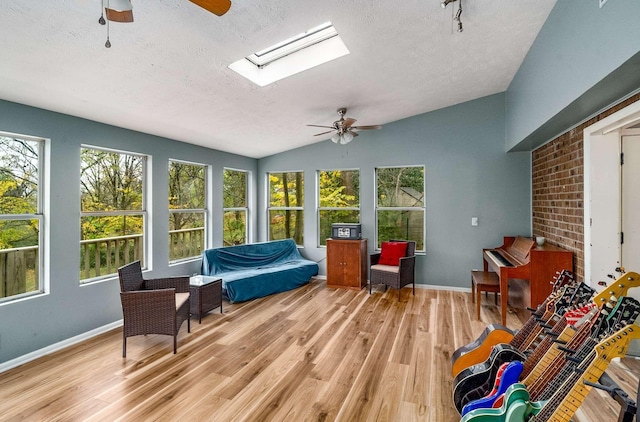 sunroom featuring ceiling fan and lofted ceiling with skylight