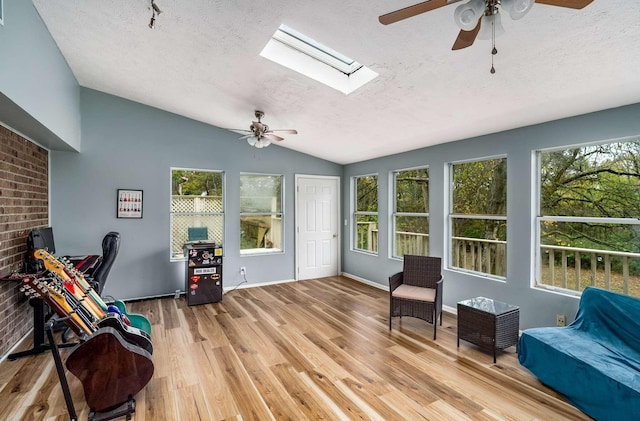 interior space featuring lofted ceiling with skylight and ceiling fan