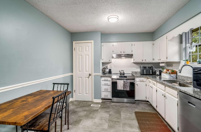 kitchen featuring sink, white cabinets, a textured ceiling, dark stone countertops, and appliances with stainless steel finishes