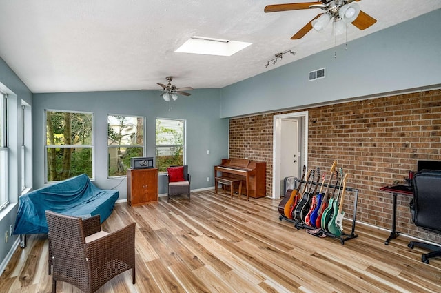 interior space featuring ceiling fan and vaulted ceiling with skylight