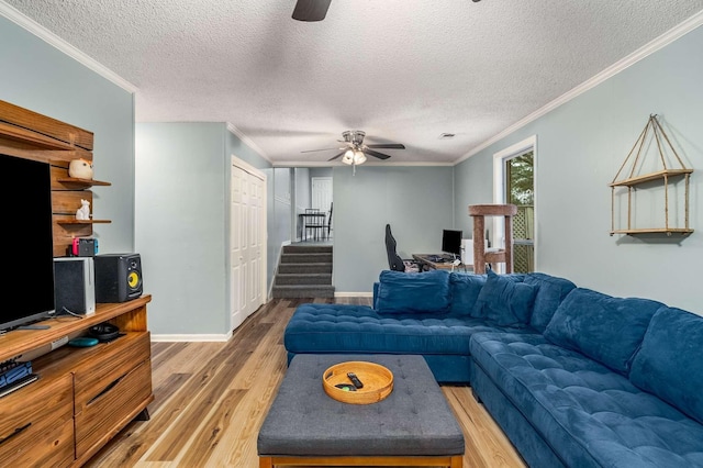 living room featuring a textured ceiling, ceiling fan, ornamental molding, and hardwood / wood-style floors