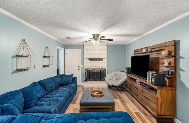 living room with a brick fireplace, ceiling fan, crown molding, and hardwood / wood-style floors