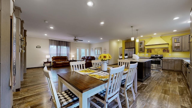 dining space featuring ceiling fan, dark wood-type flooring, and crown molding