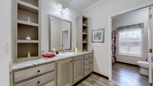 bathroom featuring ornamental molding, hardwood / wood-style floors, toilet, vanity, and built in shelves