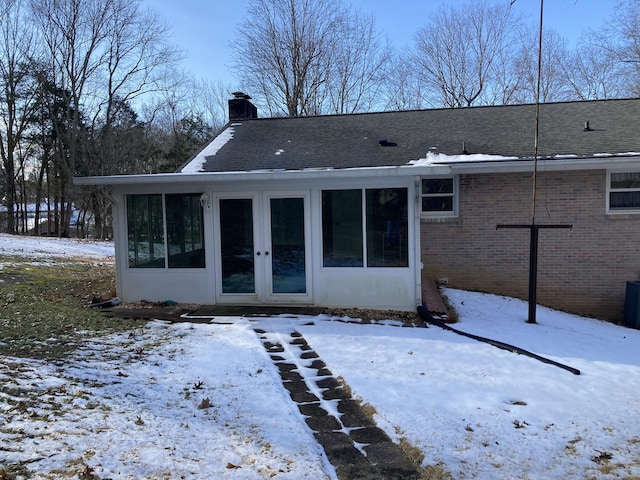 snow covered house featuring french doors