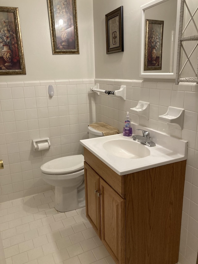 bathroom with tile walls, toilet, tile patterned floors, and vanity