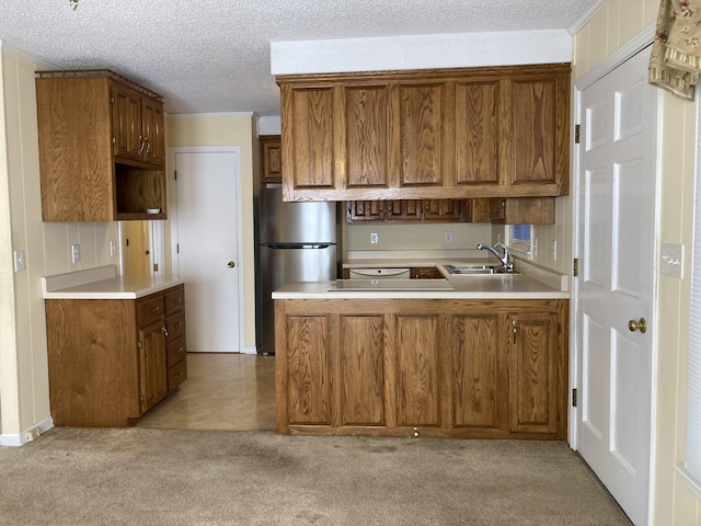 kitchen featuring kitchen peninsula, a textured ceiling, stainless steel refrigerator, light carpet, and sink