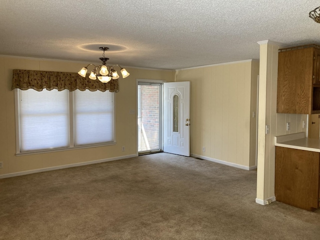 unfurnished dining area featuring a textured ceiling, a chandelier, and carpet