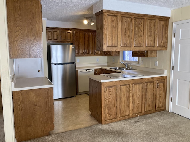 kitchen with kitchen peninsula, a textured ceiling, dishwasher, stainless steel refrigerator, and sink