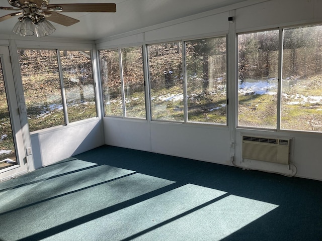 unfurnished sunroom featuring ceiling fan and a wall mounted air conditioner