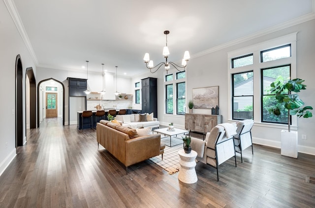 living room featuring a notable chandelier, ornamental molding, and dark hardwood / wood-style floors