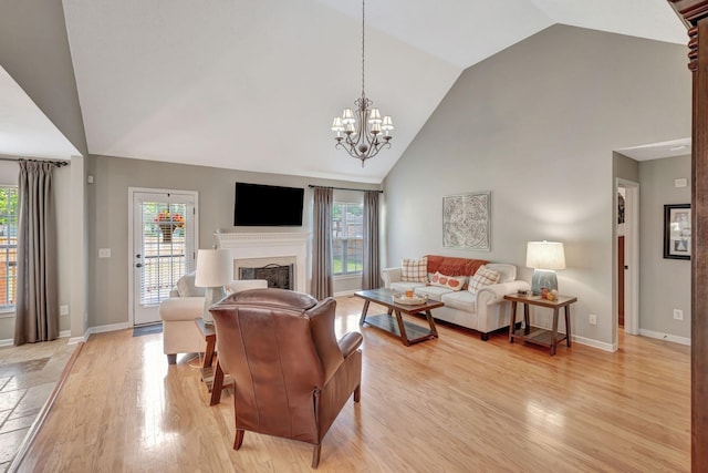 living room with light hardwood / wood-style floors, an inviting chandelier, and plenty of natural light