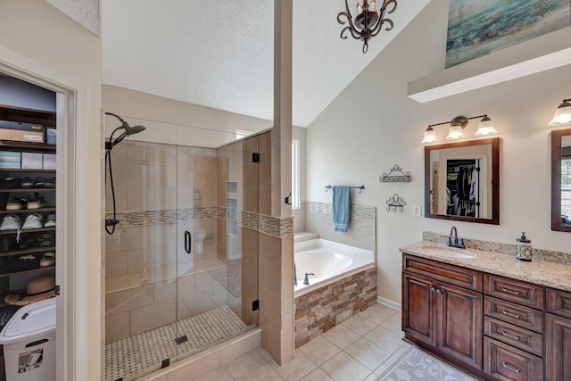 bathroom featuring a textured ceiling, vaulted ceiling, tile patterned floors, separate shower and tub, and vanity